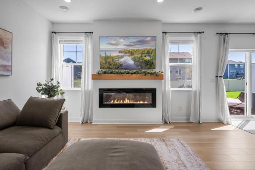 A cozy fireplace creates a wonderful focal point in the living room, framed by windows that bring in plenty of natural light