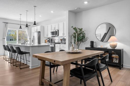 The dining area flows right into the kitchen, where modern finishes and a clean, neutral palette give the main level a fresh, polished feel