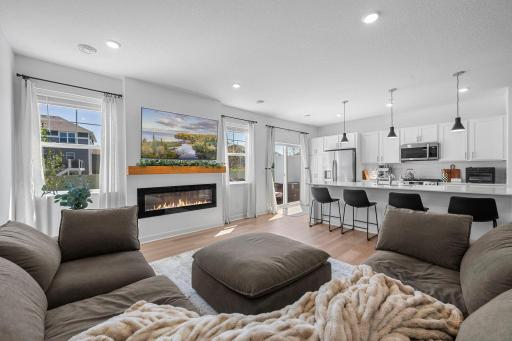 The heart of the home feels bright, open, and welcoming, with the living room flowing naturally into the kitchen and views out to the patio