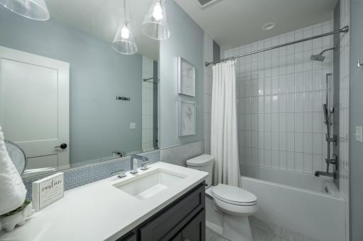 Custom stacked subway tile bath, backsplash, and lighting.