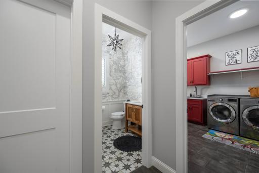 The mudroom flows into a walk-in family closet, oversized powder room, and laundry space.
