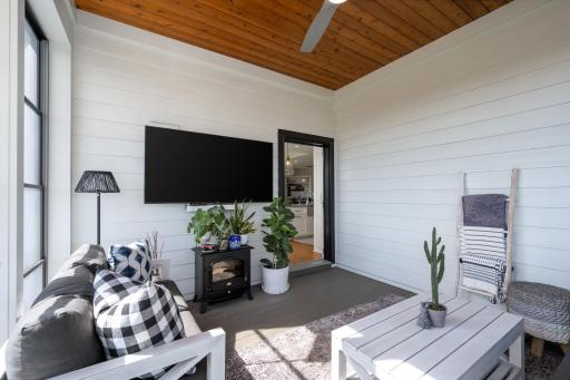 The sunroom features an electric fireplace, tongue-and-groove ceiling, and a ceiling fan.