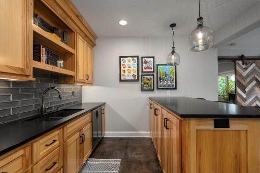 Note the Cambria countertops, custom hardware, lighting, tile backsplash, full refrigerator, undermount sink, wine fridge, microwave, and tile flooring.