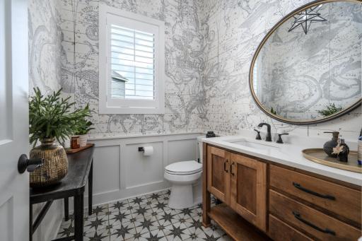 Oversized powder room 6'x7' with custom tile, vanity, and lighting.