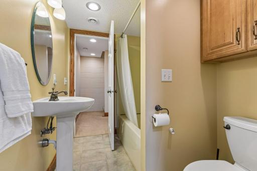 Lower level bathroom with pedestal sink and tub/shower insert