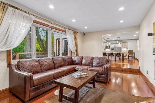 Main level family room features surround sound speakers, wood burning fireplace with views of the backyard.