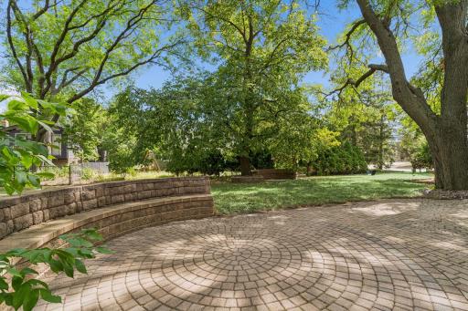 Paver patio with tiered retaining wall and mature trees