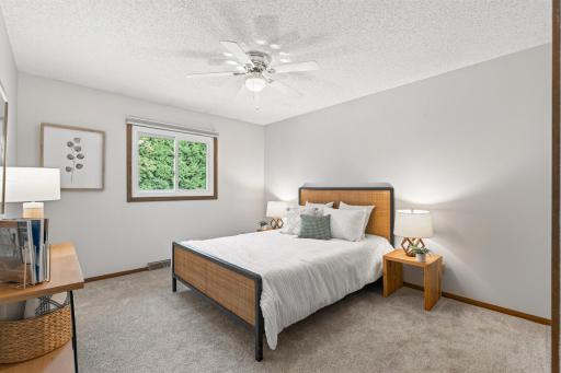Bright second upper-level bedroom with a peaceful view of the greenery