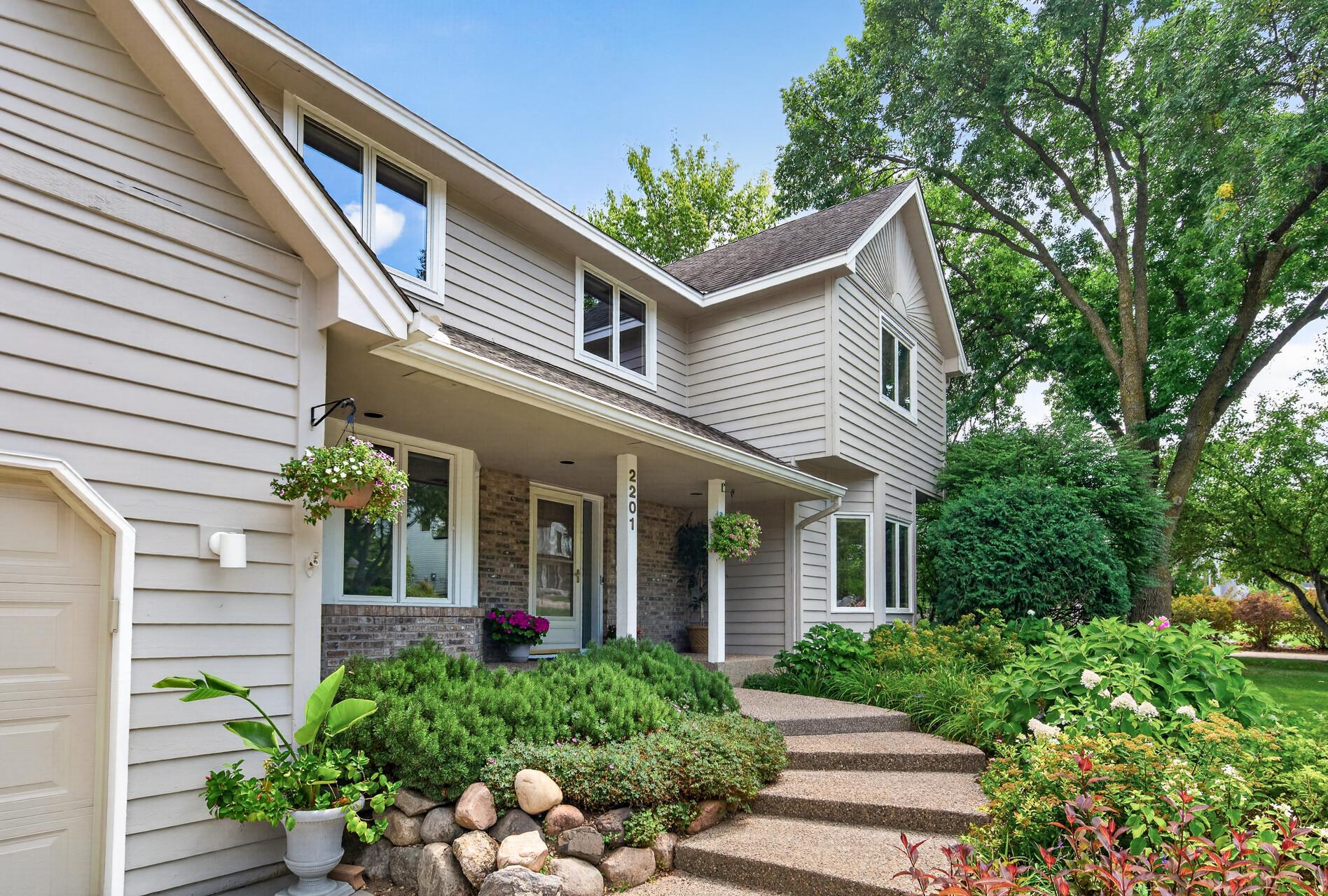 Beautiful Gardens line the walkway to the front door.