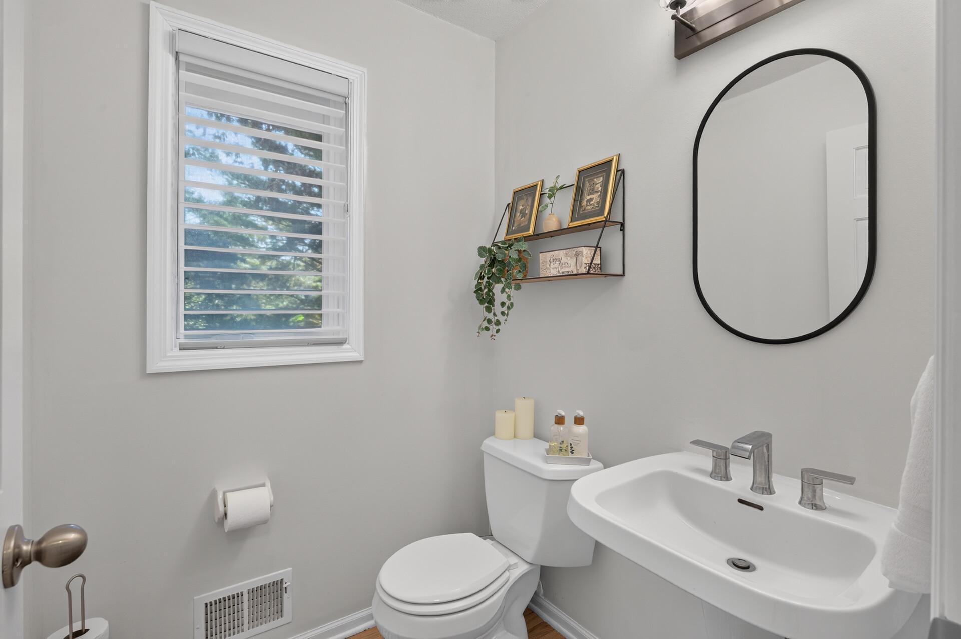 Main level half bath located in hallway by the laundry room.