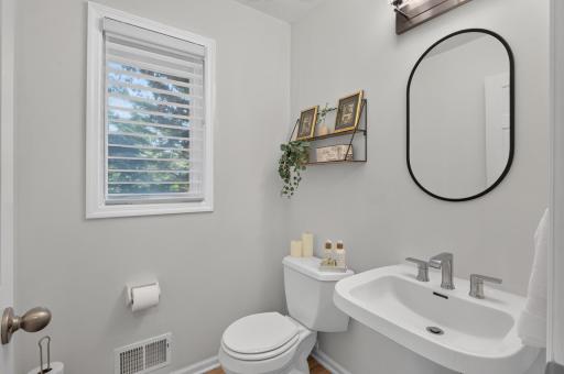 Main level half bath located in hallway by the laundry room.