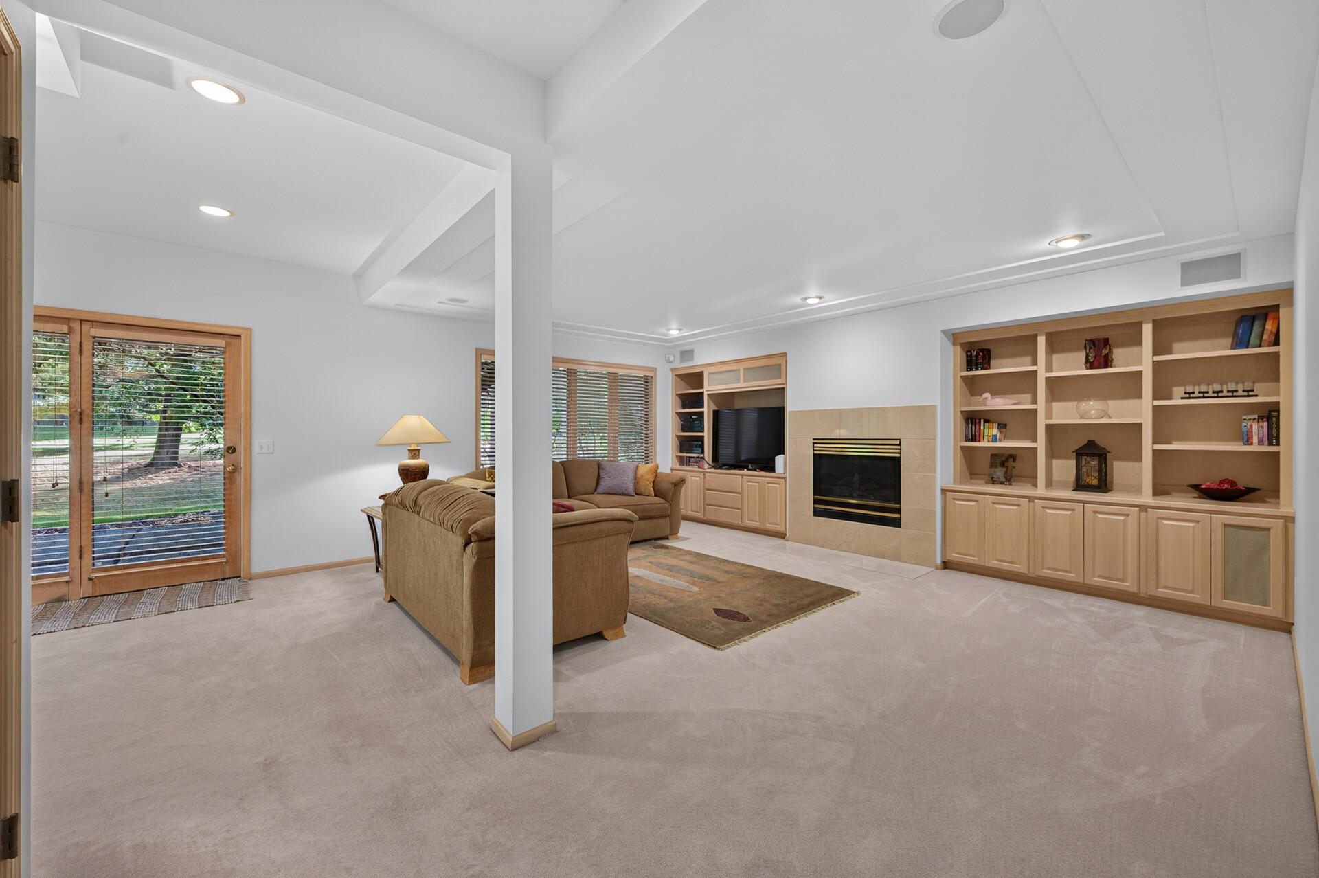 Large windows, high ceilings make this lower level family room feel open and spacious.