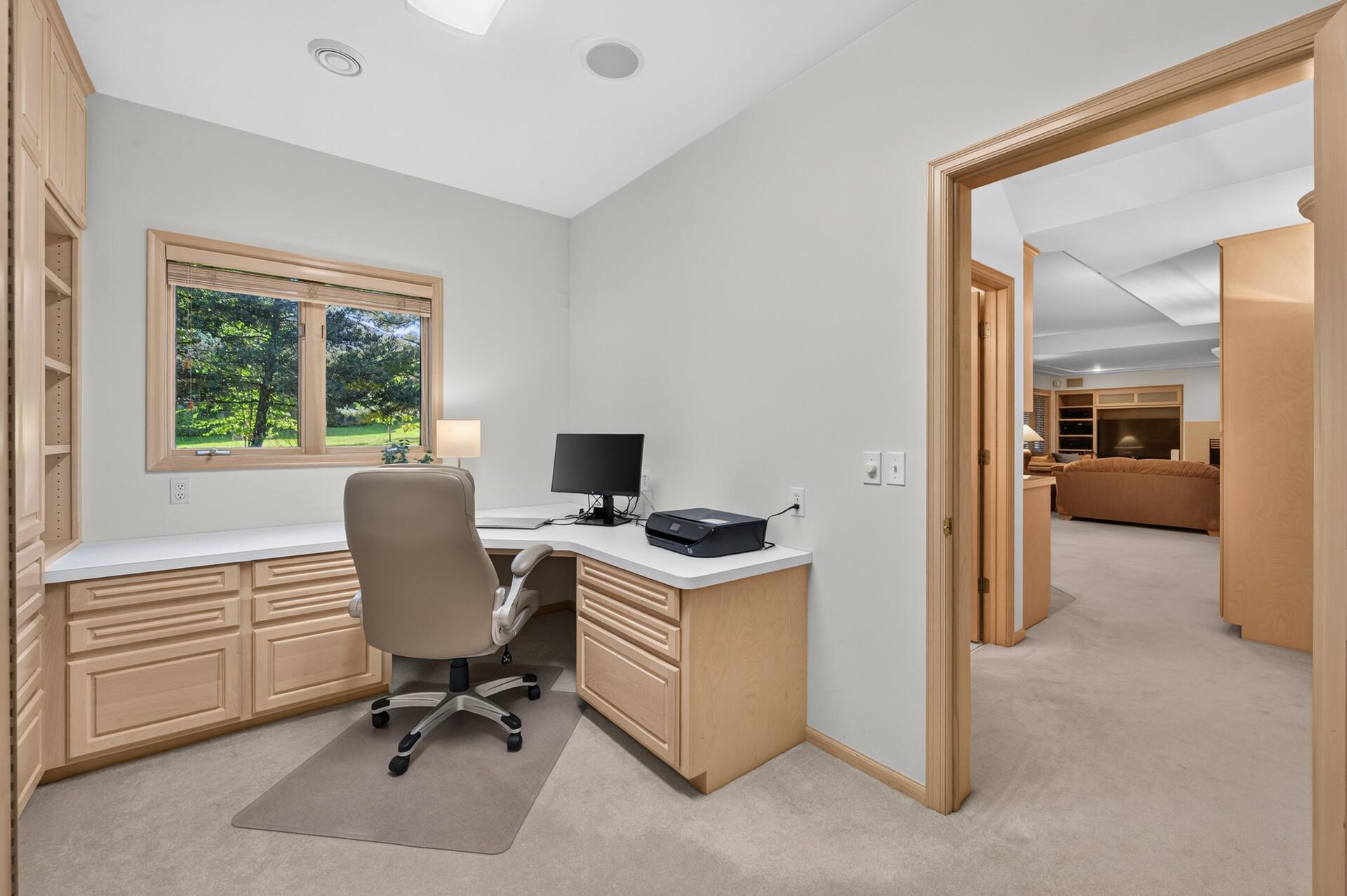 This office space has tons of storage and a view of the beautiful backyard.