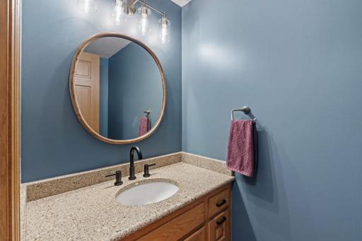 Main floor powder bathroom has new fixtures, mirror, and paint.