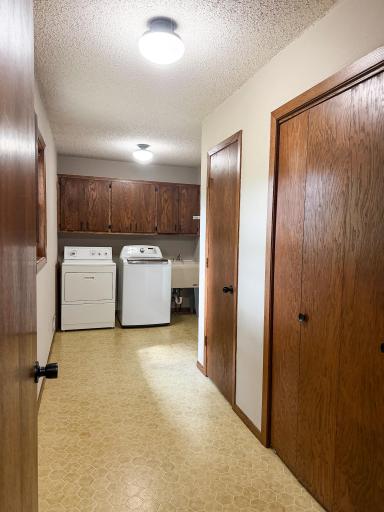 Main floor laundry room with sink and storage