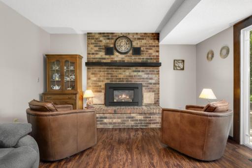 The lower-level family room is a cozy gathering space, highlighted by a fireplace that adds warmth and ambiance for relaxing or entertaining.