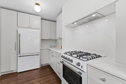 Professional-grade gas range and modern appliances anchor this stunning remodeled kitchen.