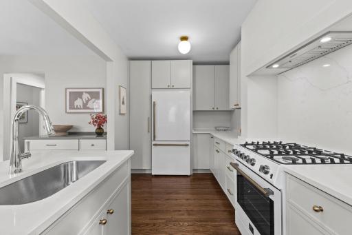 Brand new kitchen with stainless steel sink, gas range, dishwasher, and beautiful fridge.