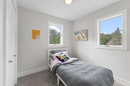 Bright bedroom with multiple windows offers serene retreat space.