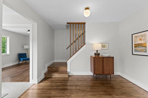 Wood staircase with refined detailing transition seamlessly to new carpet upstairs.