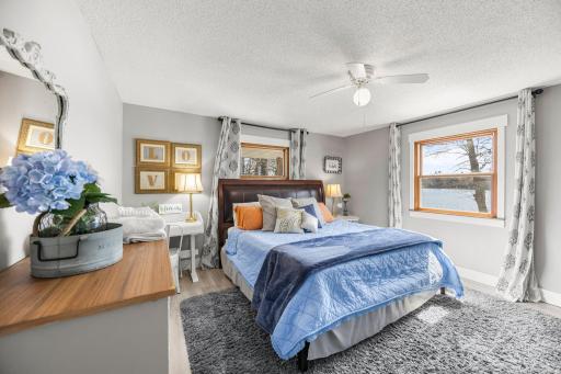 Large main floor primary bedroom with windows overlooking the water