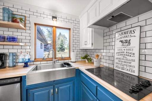 Renovated Kitchen details include stainless steel farmsink, subway tile backsplash, and a sleek glass cooktop.