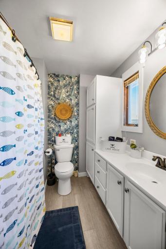 This main floor bathroom includes new toilet, bathtub, fresh coat of paint, and a fun wallpaper to elevate the look