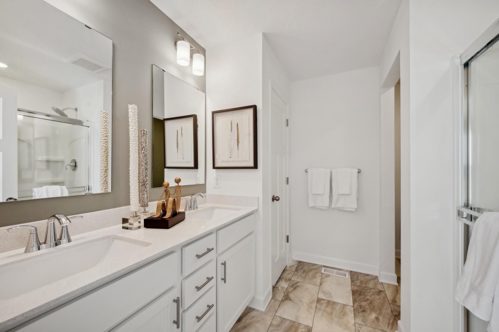 (Photo of model home, finishes will vary) An extension of the owner's suite, this private and spacious bath contains a double-vanity, a separate shower, and a walk-in closet.