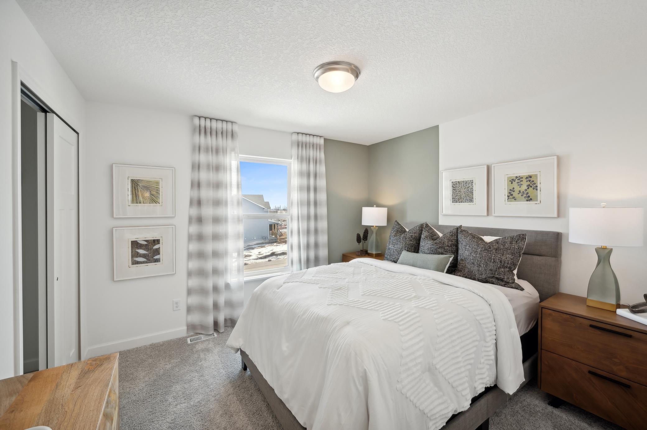 (Photo of model home, finishes will vary) One of the three generously sized upper level secondary bedroom with a spacious closet.