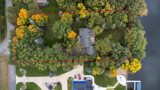 Aerial view showcasing the expansive wooded lot and beautiful waterfront setting.