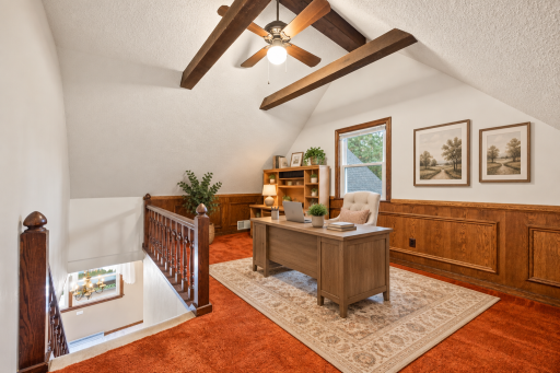 Unique upper level loft with vaulted ceiling and exposed beams ideal for a home office or play area. Virtually staged.