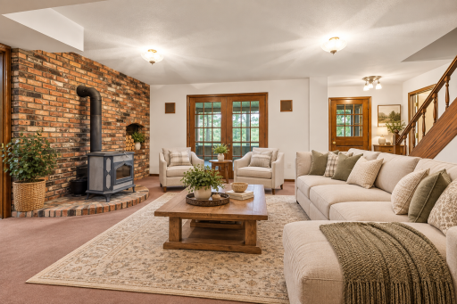 Inviting lower level family room featuring a brick accent wall and wood burning fireplace. Virtually staged
