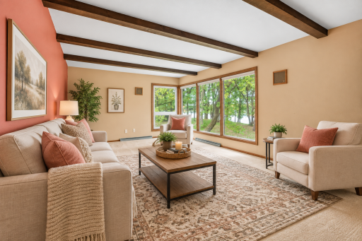 Bright and inviting living room with large windows overlooking the beautiful yard and water views. Virtually Staged