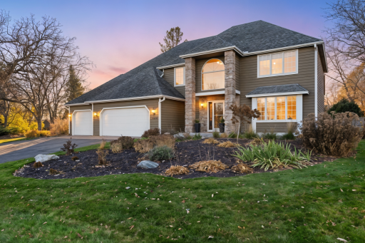 Front exterior with landscaped yard and attached garage