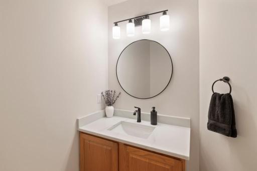 Bathroom vanity with round mirror and modern lighting