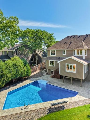 Pool and rear exterior surrounded by mature trees