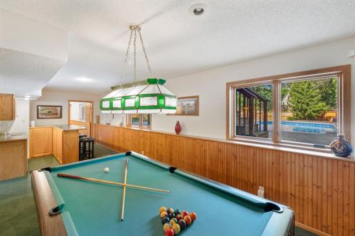 Lower-level billiards room with pendant lighting and built-ins