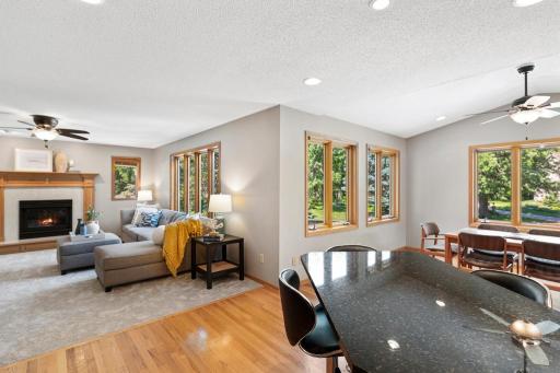 Living room with fireplace, ceiling fan and wall of windows