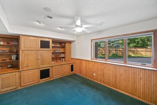 Lower-level wet bar with seating and wood cabinetry