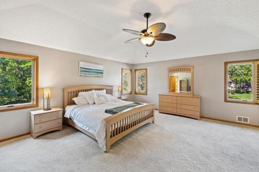 Primary bedroom with ceiling fan, carpet and natural light