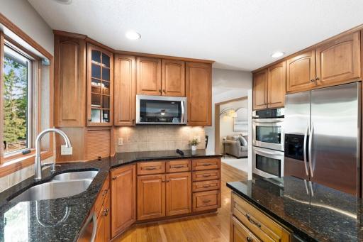 Kitchen with granite island, wood cabinetry and backyard views