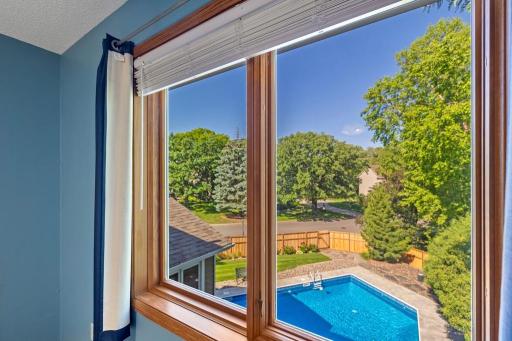 Bedroom with wood floors, ceiling fan and backyard views