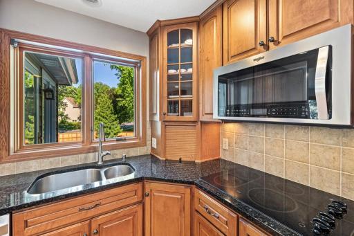 Kitchen island with granite counters and stainless refrigerator