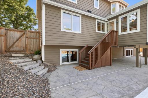 Rear exterior with walkout stairs, patio and landscaped yard