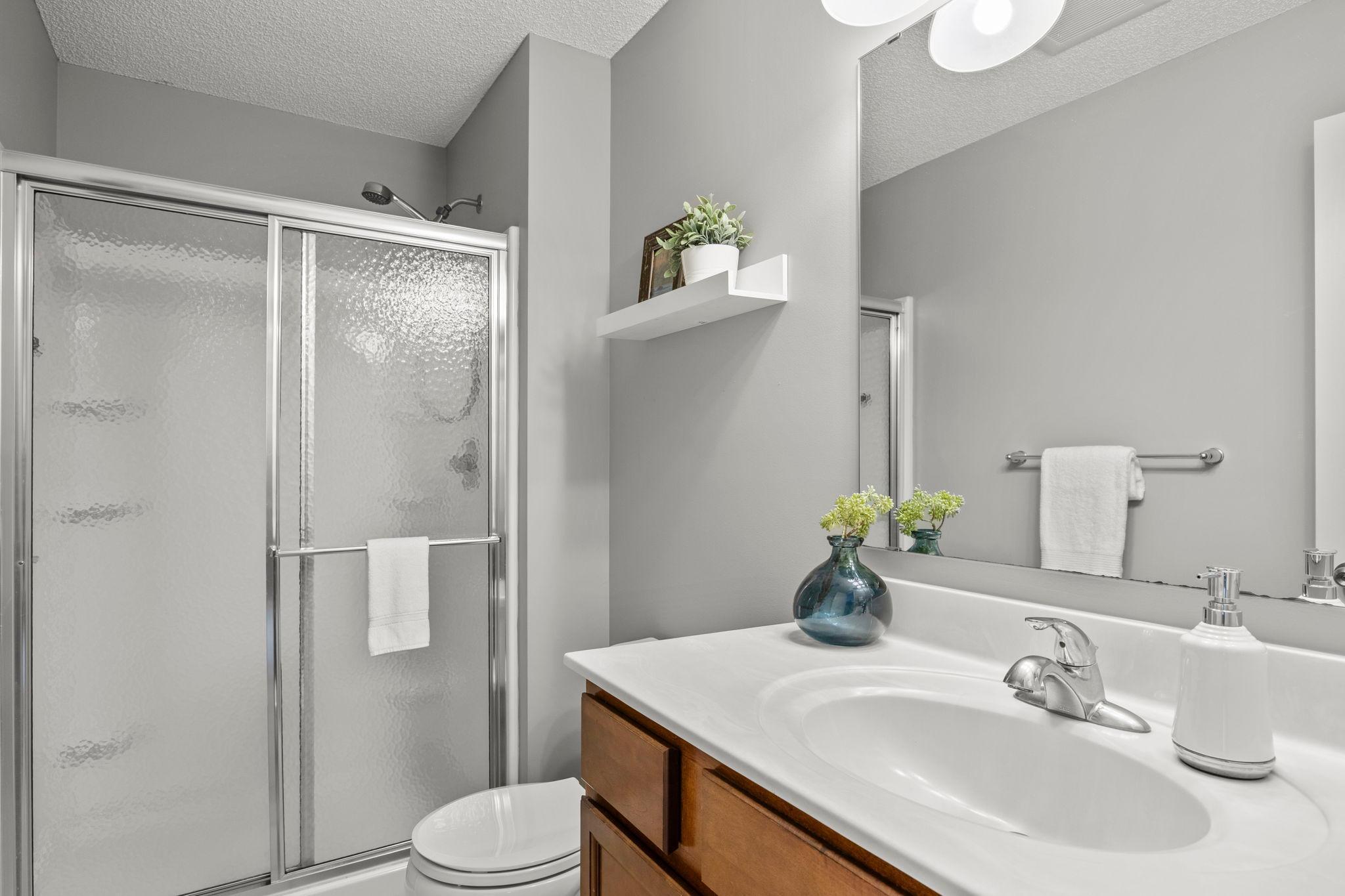 Private ensuite bathroom complete with tile flooring, vanity, and walk-in shower.