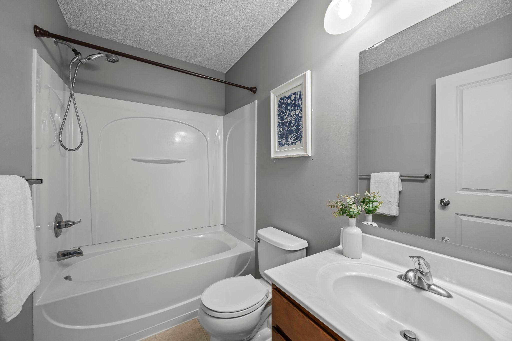 Upper-level shared full bathroom with vanity storage!
