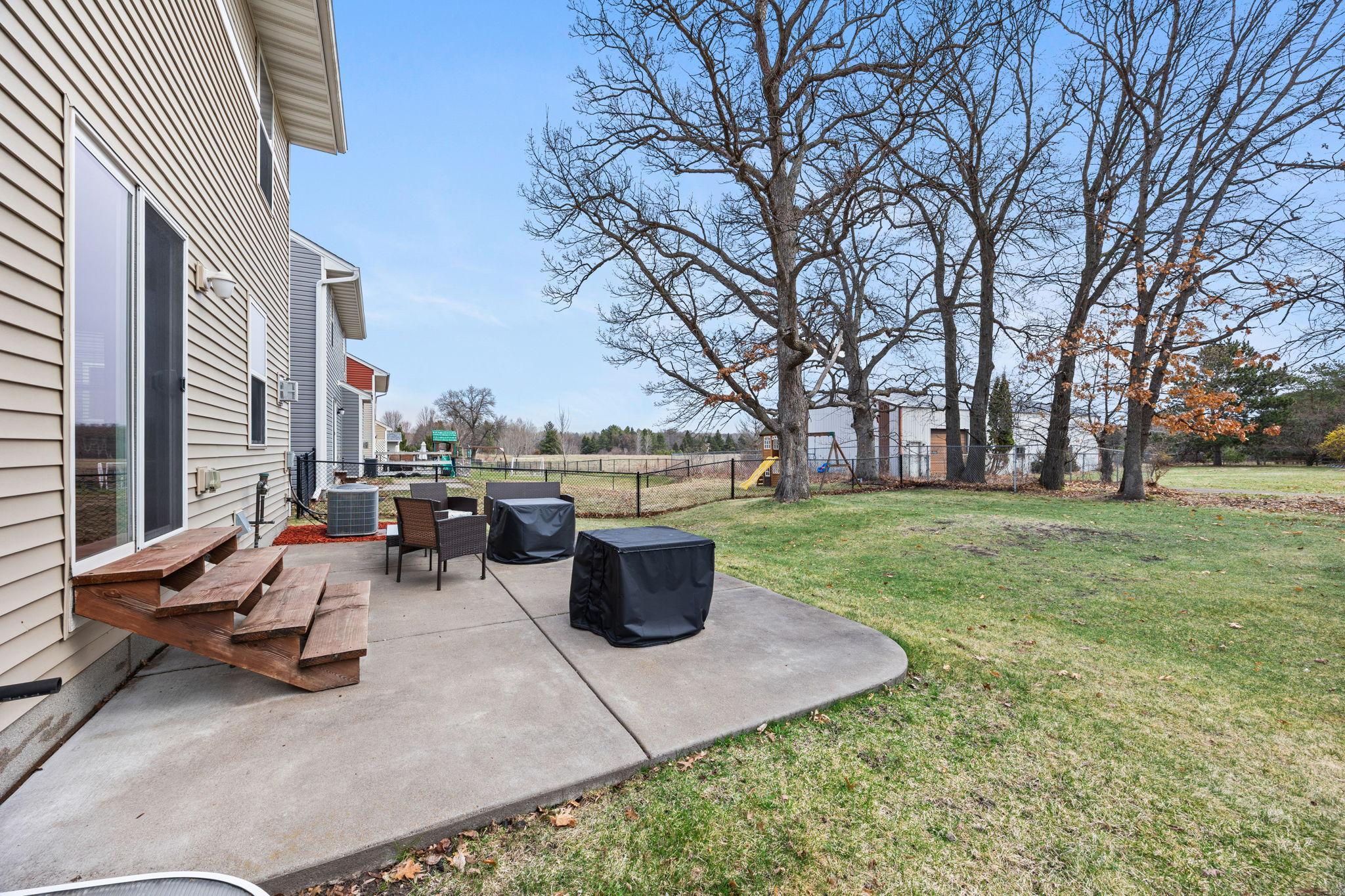 Private backyard patio framed by mature trees and open space! Perfect for quiet mornings or evening gatherings.