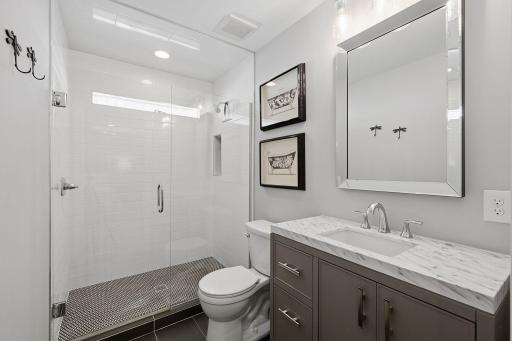A step-in shower and modern, clean tilework await in your private bath.