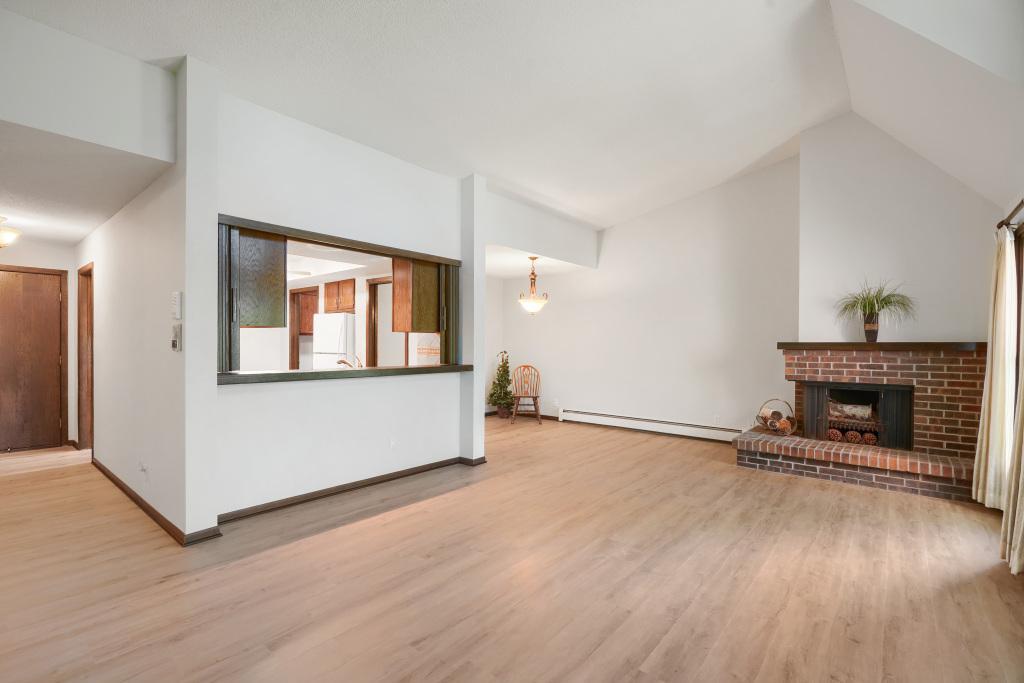 Vaulted living room with counter seating into kitchen, spacious dining area and fireplace (never used by current owner)