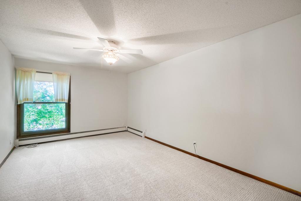 Primary bedroom with new carpet and ceiling fan.